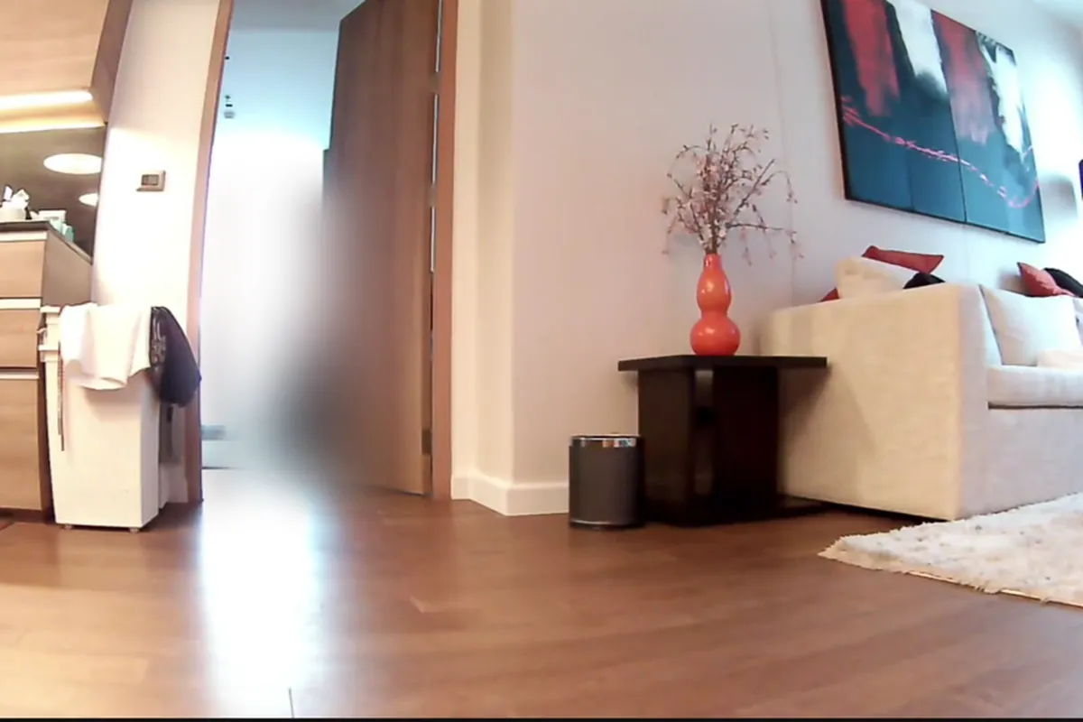 A real view from our robot's camera: a room with a doorway, a side table and a sofa, seen from floor height